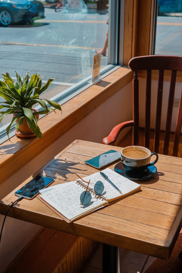 Table by window with open book and coff